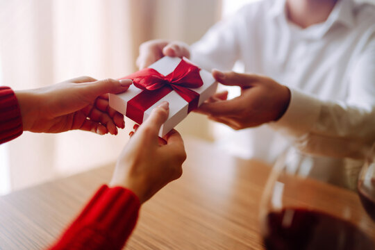 Exchange of gifts.  Young couple in love offering gift to each other for valentine day or birthday. Romantic day. Winter holidays.