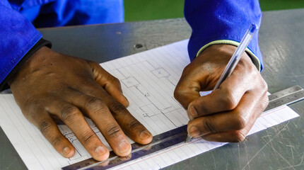 Closeup of a man using a ruler on drawing an architectural map, vocational skills