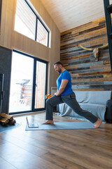 A man warms up his muscles before exercising. Online training with a tutorial from the Internet.