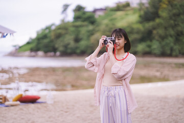 Asian travelling woman be smile with classic 35mm rangefinder film camera, woman relaxing in holiday summer