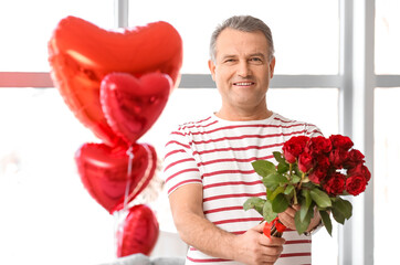 Mature man with bouquet of flowers for his wife at home on Valentine's Day