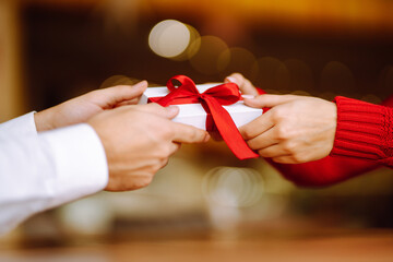 Exchange of gifts.  Young couple in love offering gift to each other for valentine day or birthday....