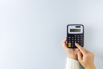 a calculator in a hand on white background. - Saving money for finance accounting concept.