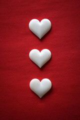 Three white hearts on a red background