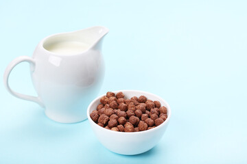 Chocolate corn flakes with milk in jar on blue background