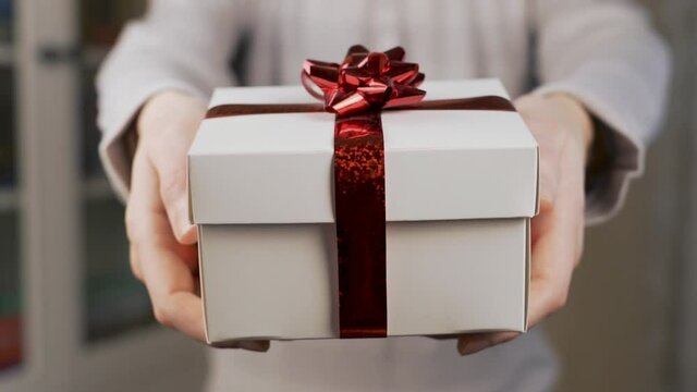 Close-up of A Man's Hands Giving A Gift to His Beloved in a White Box with a Red Flower, Close-up of a Surprise Gift and a Man's Hands.