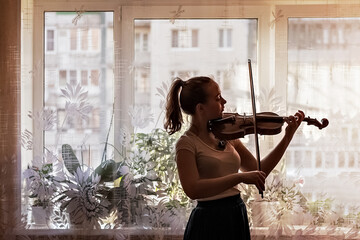 Silhouette of a young girl, a musician. Playing the violin in the background of the window © Светлана Густова