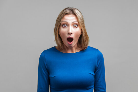 Wow, I can't believe this! Portrait of astonished woman with stunned shocked face. indoor studio shot isolated on gray background