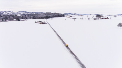 Postauto auf verschneiter Strasse