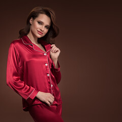 Pin-up girl in red silk pajamas on brown background