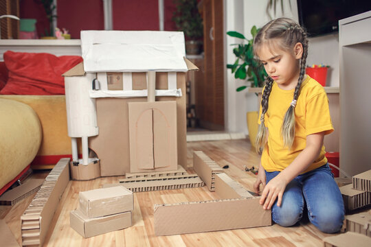 Zero waste home activity. Kids doing paper house with cardboard box, creatively thinking concept