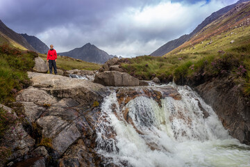 woman in red standing at falls at Glen Rosa on Arran