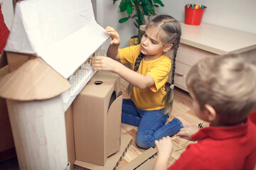 Zero waste home activity. Kids doing paper house with cardboard box, creatively thinking concept