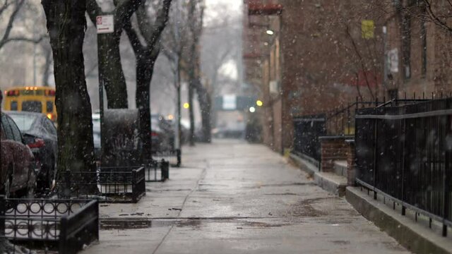 Snow tumbling down on cold winter Brooklyn street, in New York - Long medium shot