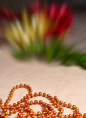 Background on craft paper are orange beads, gold and red tinsel, green spruce branches. Decor, decoration for the New Year and Christmas