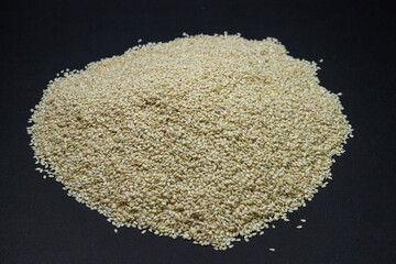 Heap of sesame on a black background. White sesame. Baking sprinkles