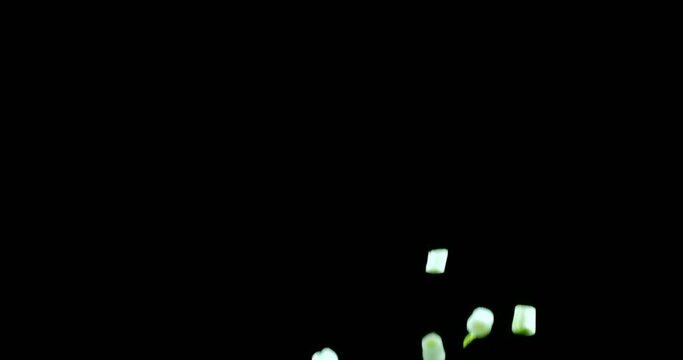 Fresh green onion leaves slowly fly up and fall on a black background. Blackmagic Ursa Pro G2, 300 fps.