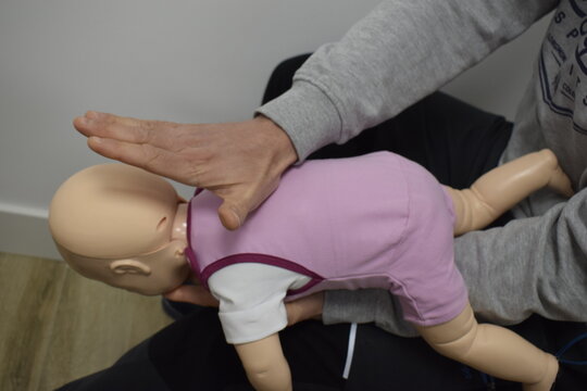 Personal sanitario mostrando con un maniqu&iacute; c&oacute;mo hacer reanimaci&oacute;n cardiopulmonar a un beb&eacute; RCP