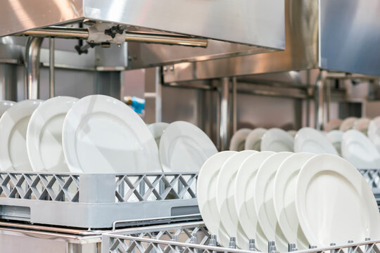 Many White Plate On Basket In Automatic Dishwasher Machine For Cleaning In Kitchen Room Restaurant