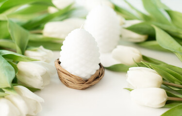 Easter candle egg and white tulips flowers on white background. Greeting card