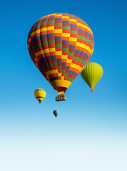 Colorful Hot Air Balloons for promotion of your travel agency or tour to Cappadocia, vertical landscape. Ballooning trip at clear blue sky background with copy space for text, bottom up view.