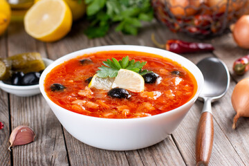 Solyanka, Russian soup with sausage, olives, pickled cucumber and capers
