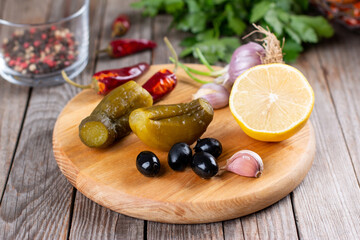 Cucumbers, olives, garlic on a board. Pickles for cooking savory dishes