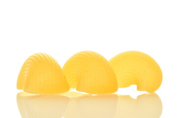 Bright yellow uncooked pasta, close-up, isolated on white.