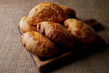 Homemade pies made from yeast dough, on a wooden board, on sacking