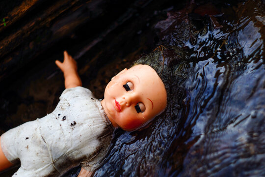 Corpse of a dead doll floating in water