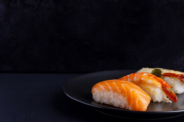 Nigiri sushi set on black background, traditional Japanese food.