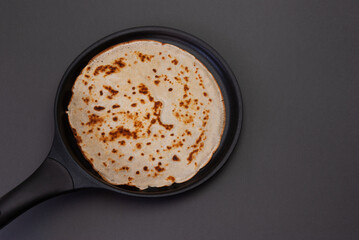 A delicious looking pancake cooking in a pan