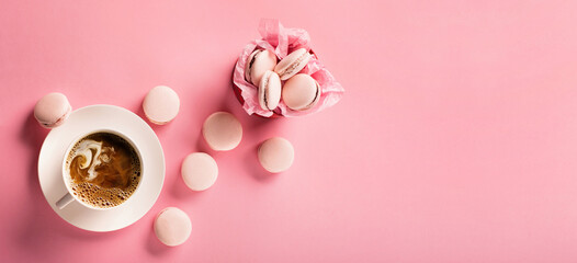 Morning cup of coffee, sweet cake macaroons, gift present box on pink background.