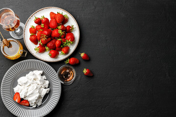 Fototapeta na wymiar Cream cheese and fresh strawberries on black background
