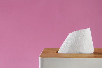 Holder with paper tissues on pink background, closeup. Space for text