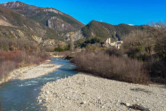 Typical provencal village dominating the river running between mountains in Baronnies national park, french Drôme region.