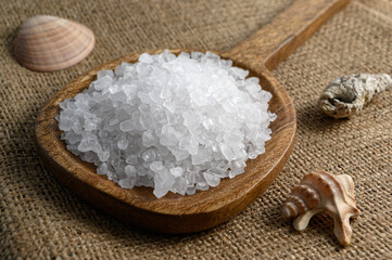 Sea salt in wooden spoon on sackcloth