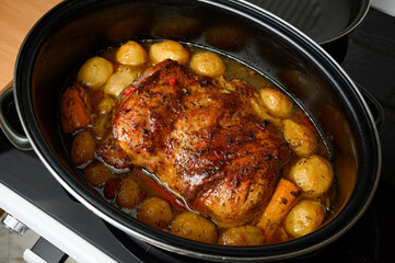 Homemade roast pork with potatoes in black roaster