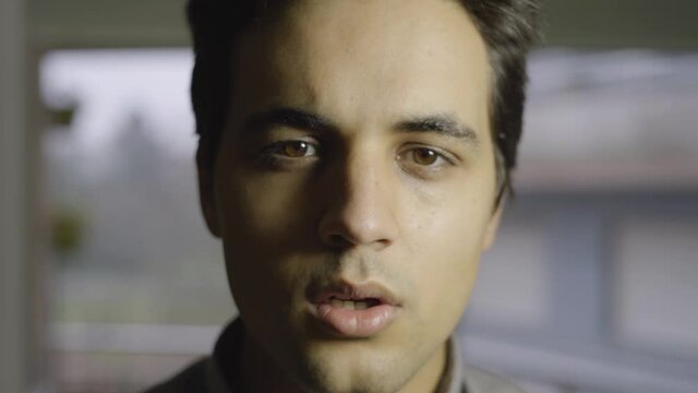 Close-up Of Dark-haired Man Taking Off His Mask And Smiling At Camera. Boy With Latino Features And Dark Eyes Of A Person With A Smile.
