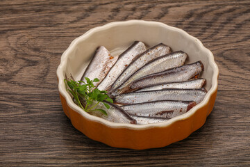 Anchovies in the bowl served basil leaves
