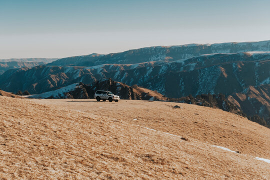 Photo of an SUV in the mountains. Autotourism. A car at the top of the mountains. 