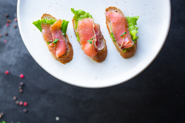 Smorrebrod sandwich salmon fish bruschetta with seafood antipasto aperitif on the table for healthy meal snack outdoor top view copy space for text food background 