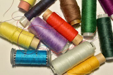 A set of spools with multi-colored threads on the table.