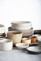Fototapeta na wymiar handmade ceramics, empty craft ceramic plates and bowls on light background, selective focus