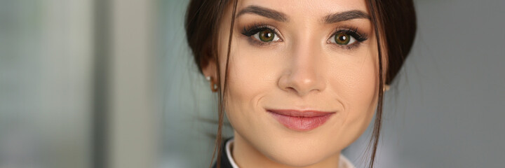 Close up of happy beautiful businesswoman wearing black jacket and staying in the office while smiling