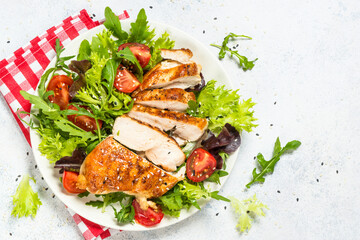 Grilled chicken with green salad. Keto diet, healthy eating. Top view on white table with space for text.