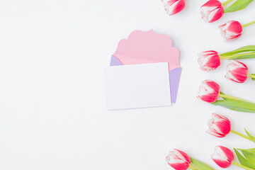 Mockup white greeting card and envelope with pink tulips on a white background