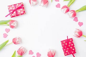 Flat lay valentines day frame with pink tulips and gift box on a white background