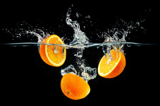 fresh orange splices with water splashes