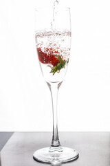 Filling up the champagne glass with strawberry isolated on a white background copy space